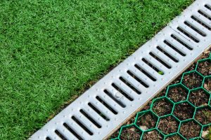 Lawn edge beside a slotted surface drain that carries off heavy rain