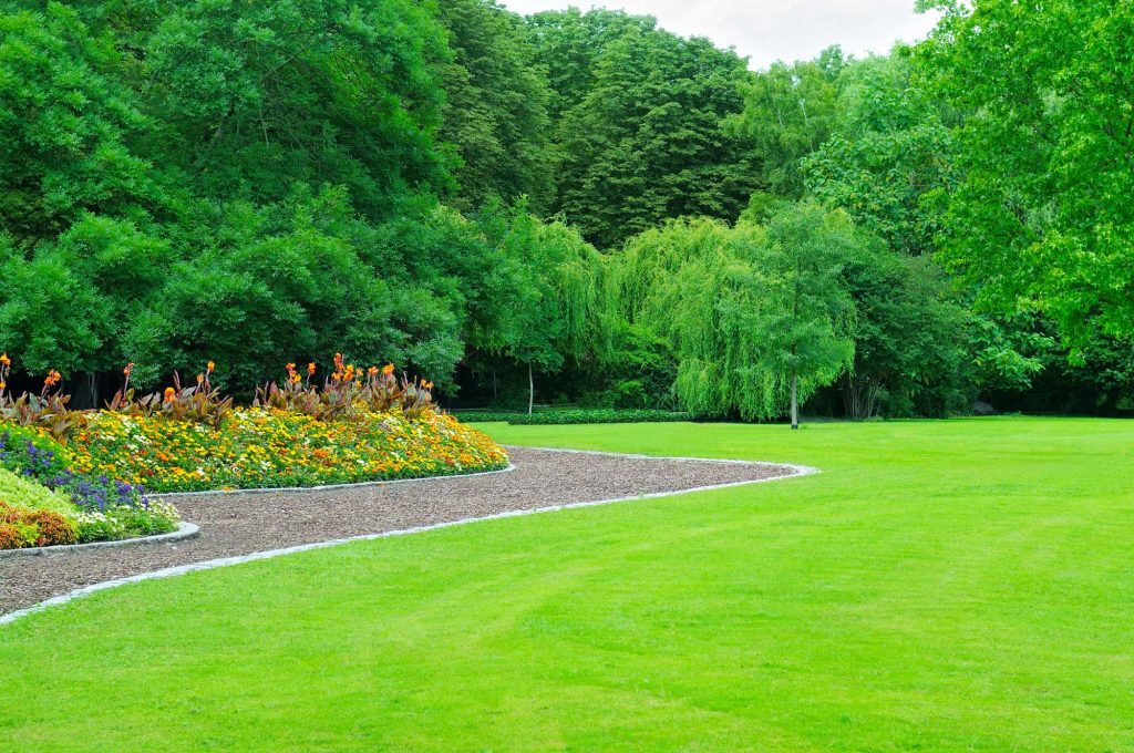 Wide manicured lawn bordered by flower beds
